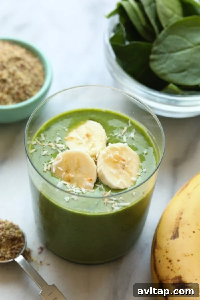 Energize your morning with this delicious and healthy Banana Matcha Smoothie, packed with the goodness of matcha, bananas, and spinach. Vibrant green banana matcha smoothie in a glass with a straw, garnished with banana slices and a sprinkle of matcha powder.