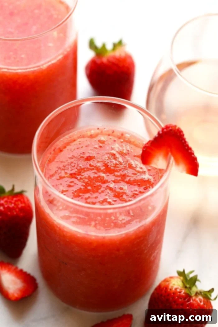 The most delicious summer drink you ever did see! This Strawberry Peach Frose recipe is such a fun frozen drink to make for a crowd. This easy frose recipe calls for a full bottle of rose, frozen strawberries and peaches, rum, and agave nectar! A glass of perfectly blended strawberry peach frosé, garnished and ready to enjoy.