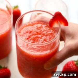 A vibrant glass of strawberry peach frosé, perfectly garnished and ready to be enjoyed as a refreshing summer drink.