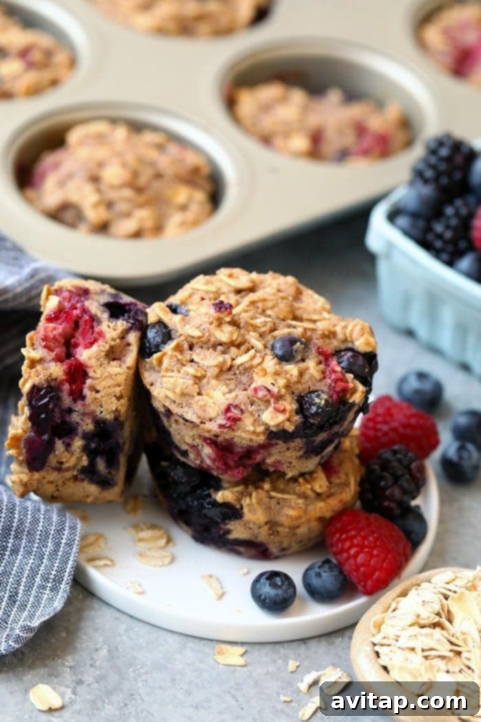 Ready-to-Enjoy Triple Berry Baked Oatmeal Cups Stack of freshly baked triple berry oatmeal cups on a white plate