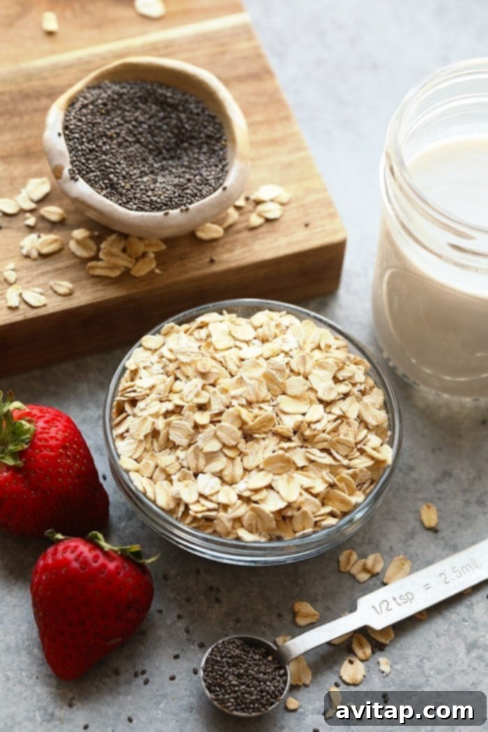 Individual bowls holding rolled oats, chia seeds, almond milk, and maple syrup, ready to be combined for overnight oats.