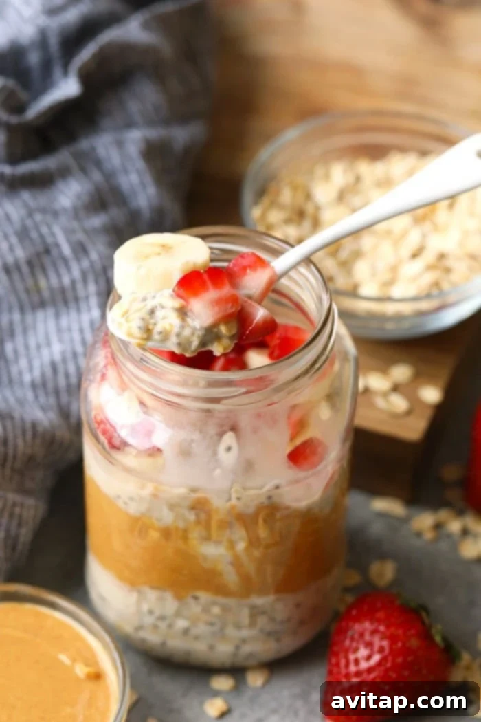 A spoonful of vegan overnight oats, generously topped with strawberries and bananas.