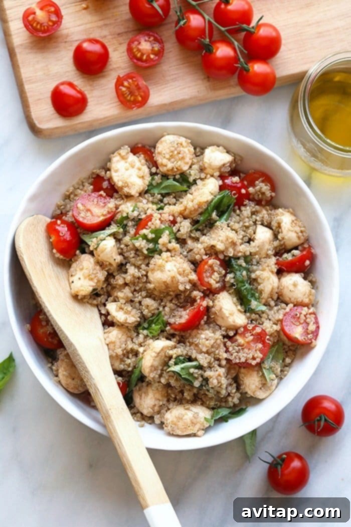Fresh Caprese Quinoa Salad: A Healthy and Flavorful Summer Delight Fresh Caprese Quinoa Salad artfully arranged in a rustic bowl, showcasing vibrant colors of red tomatoes, white mozzarella, green basil, and golden quinoa, ready to be served.