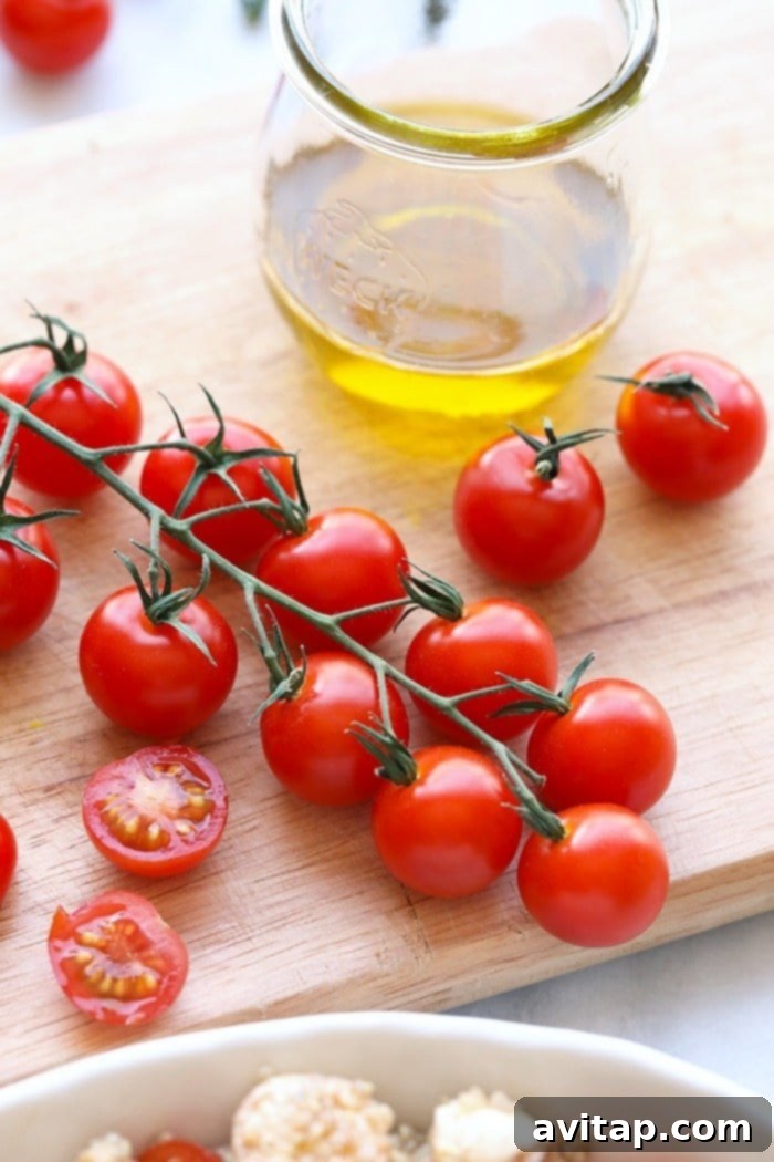 Fresh Cherry Tomatoes: Key to a Perfect Caprese Quinoa Salad Close-up of vibrant red cherry tomatoes, freshly washed and ready to be halved for the Caprese Quinoa Salad, highlighting their ripe, juicy appearance and promising fresh flavor.