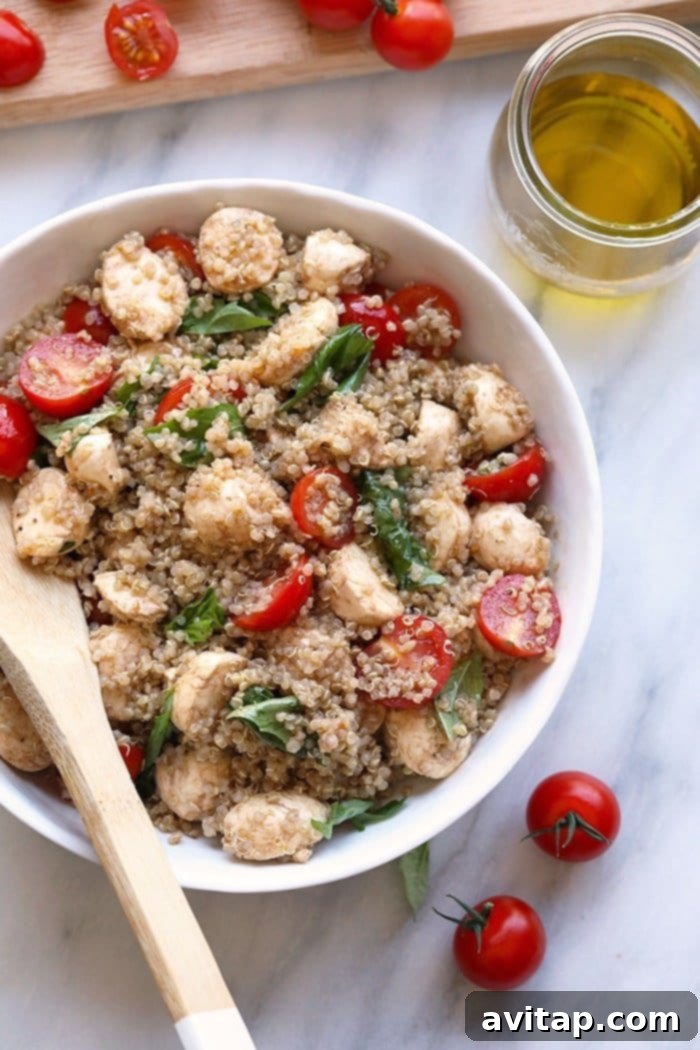 Ready-to-Serve Fresh Caprese Quinoa Salad A large, aesthetically pleasing bowl filled with Fresh Caprese Quinoa Salad, perfectly mixed and ready to be served. Garnished with extra fresh basil leaves, highlighting its vibrant and appetizing nature.