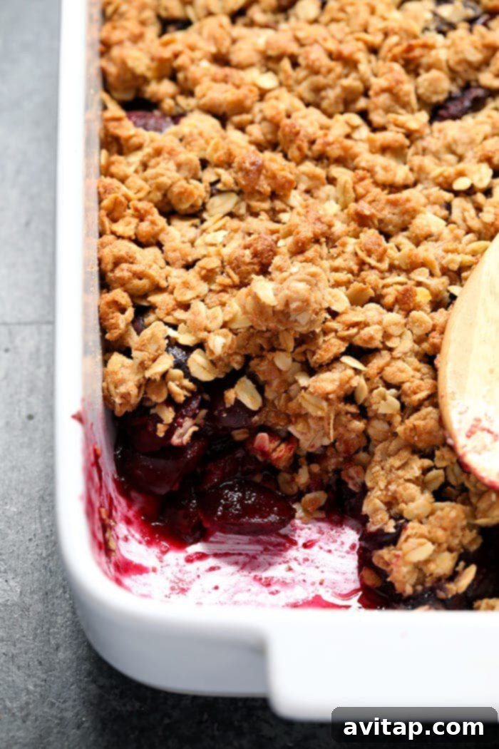Freshly baked cherry crisp, golden brown and bubbly, in a glass baking dish
