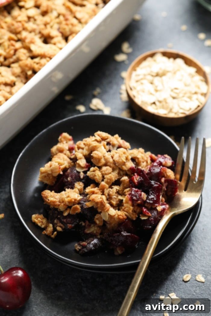 Plated cherry crisp with a generous scoop of vanilla ice cream
