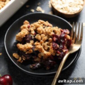 cherry crisp on plate with ice cream