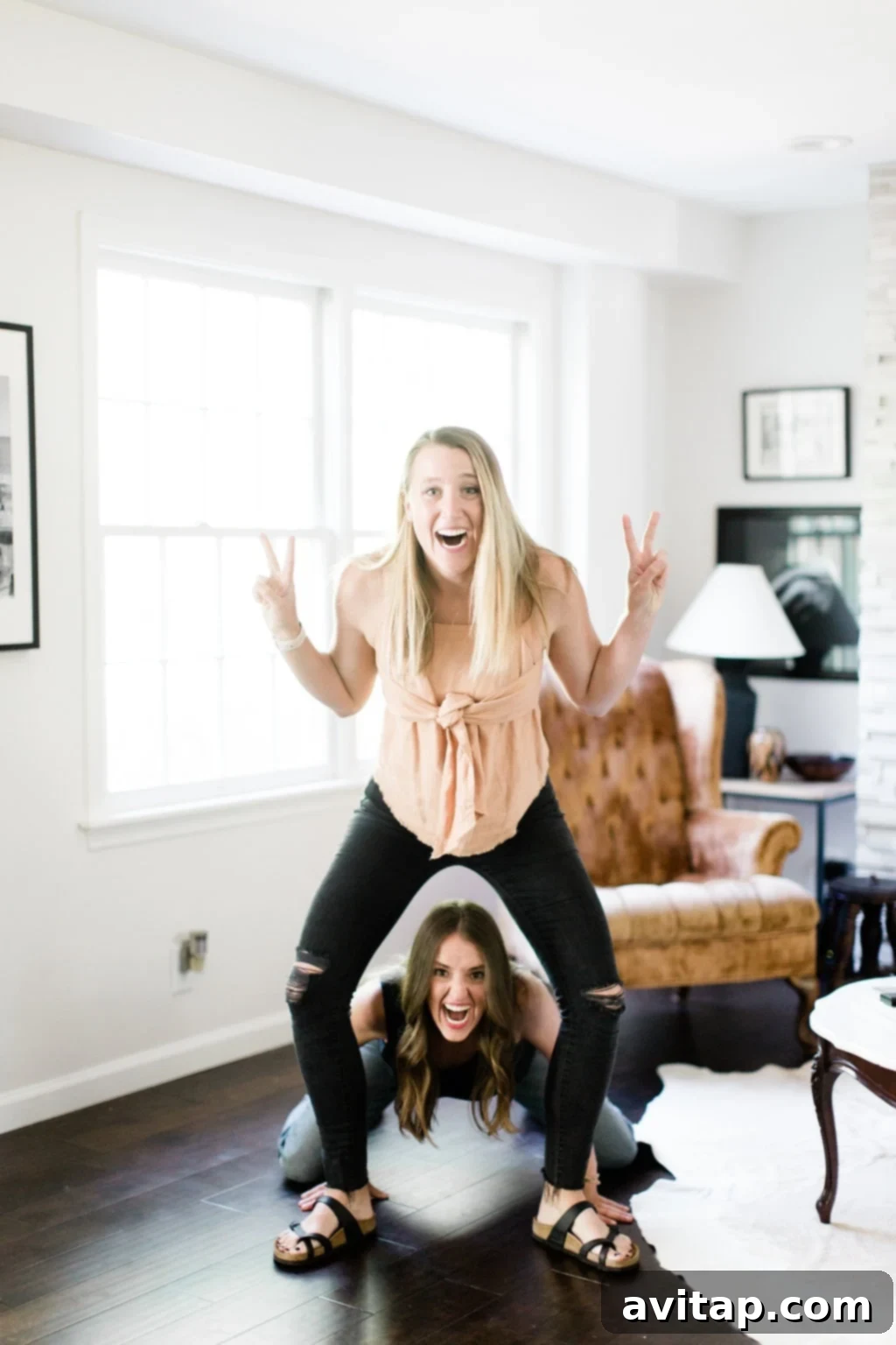 Two smiling women from Fit Foodie Finds showcasing a sign that reads 'You're so annoying!', turning a negative comment into a humorous moment.