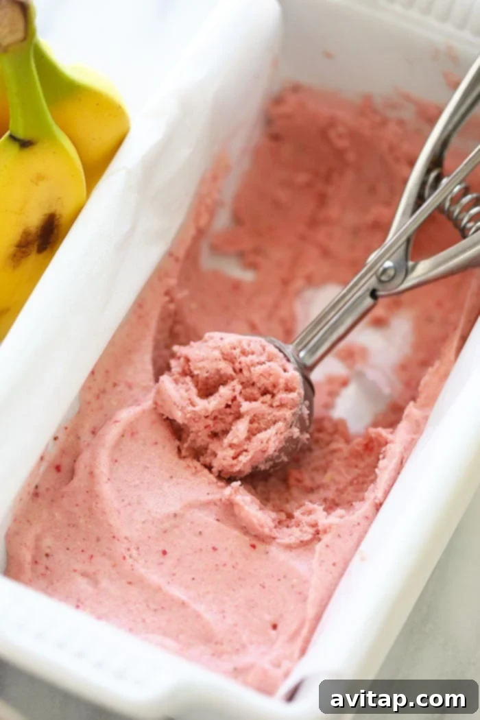A perfectly scooped ball of Protein Strawberry Banana Nice Cream in a small bowl, showcasing its smooth texture.