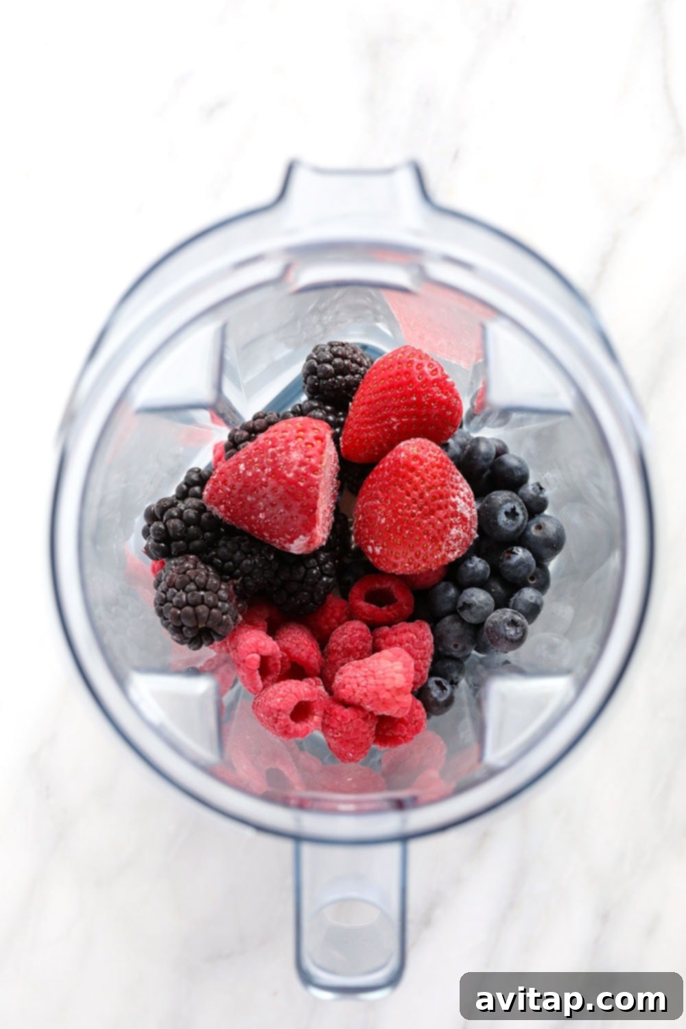 Frozen berries in a blender, ready to be processed into a smoothie or other delicious concoction.