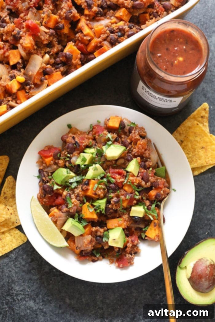 A single serving of quinoa casserole in a white bowl, garnished with fresh cilantro and avocado.