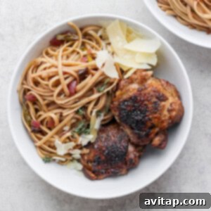 Two bowls of chicken pasta topped with parmesan.