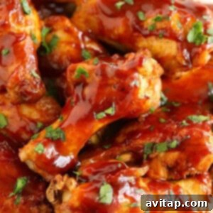 Crock pot chicken wings smothered in BBQ sauce neatly arranged on a plate.