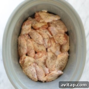 chicken in a crock pot on a marble countertop.