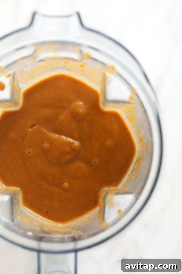 Blended Pumpkin Coffee Smoothie Close-up of a blender filled with smoothly blended pumpkin coffee smoothie, showing its creamy texture and rich color.