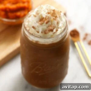 A delicious pumpkin coffee smoothie in a jar, with whipped topping, ready to drink.