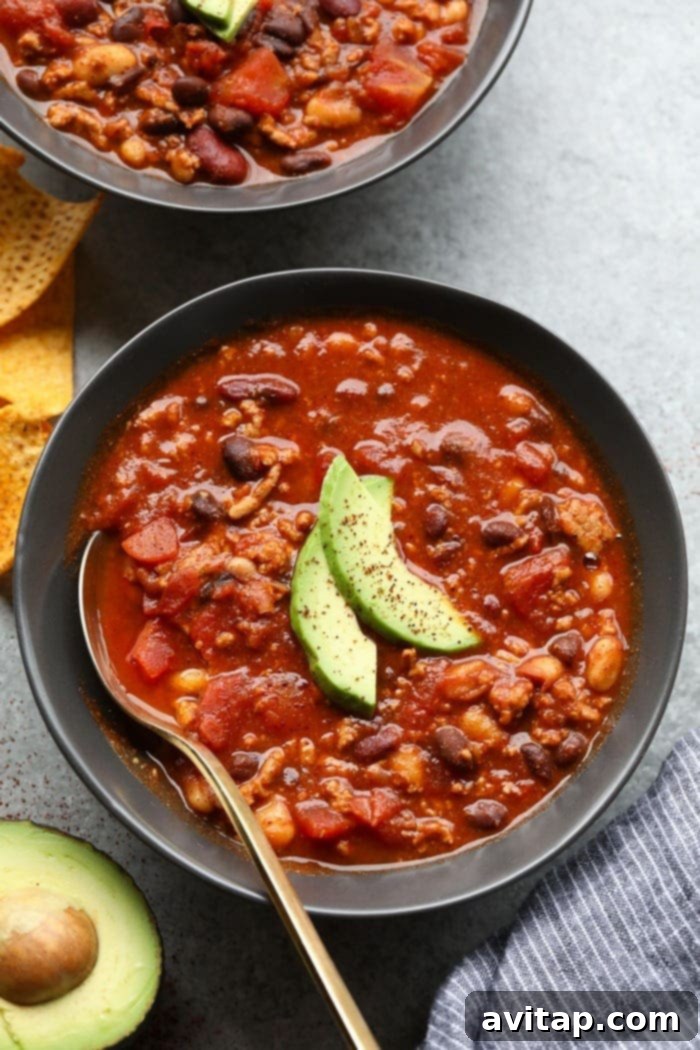 Healthy turkey chili in a vibrant bowl, garnished with fresh cilantro and a dollop of sour cream.