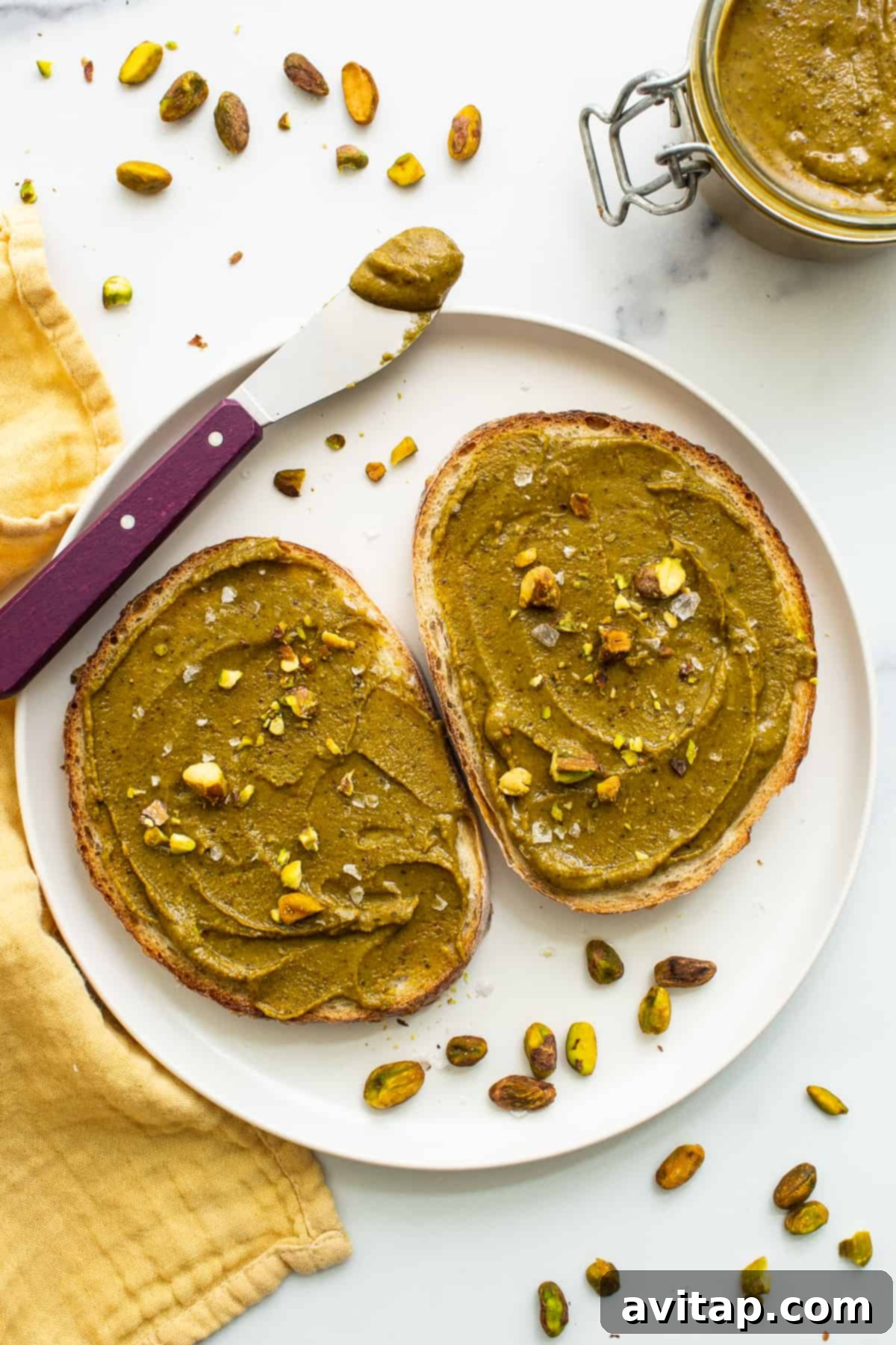 Homemade pistachio butter generously spread on a slice of toast.