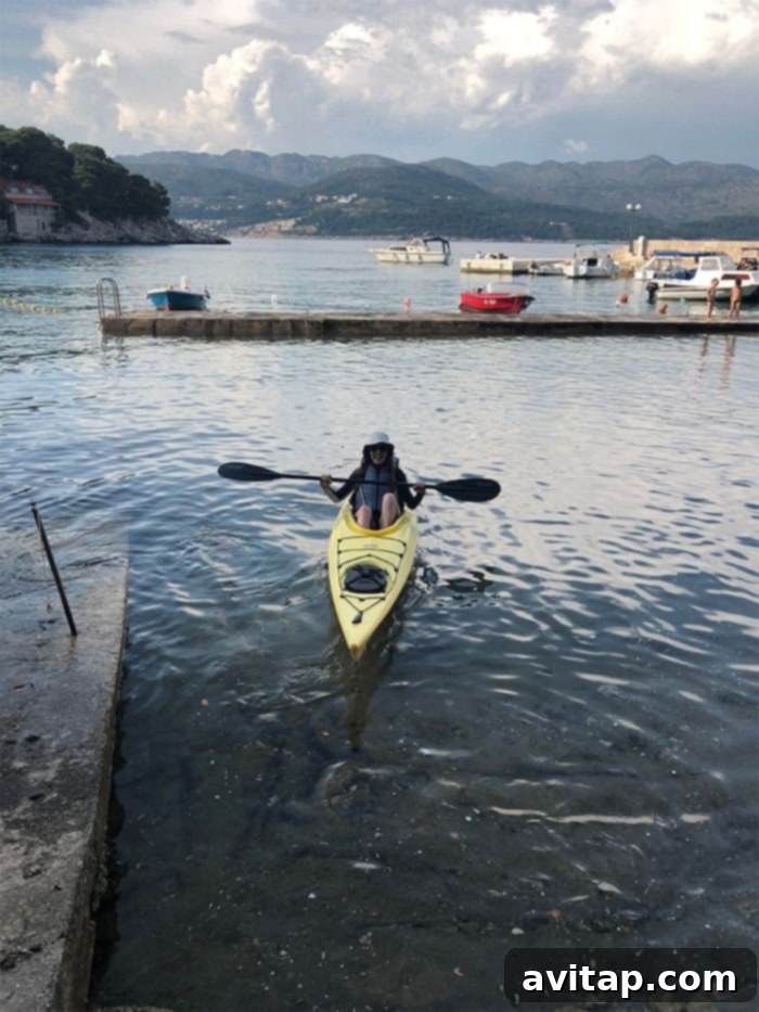 Kayaking Croatia: Exploring the Adriatic's Hidden Gems A woman kayaking in the crystal-clear waters of the Adriatic Sea off the coast of Croatia.