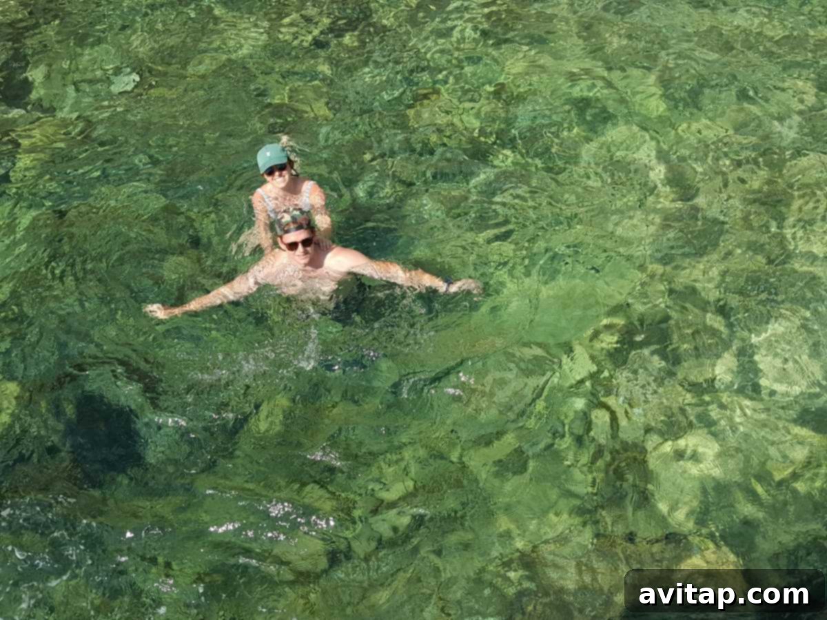 Swimming in Croatia's Crystal Clear Adriatic Coves People enjoying a refreshing swim in the clear blue waters of a secluded cove in Croatia.