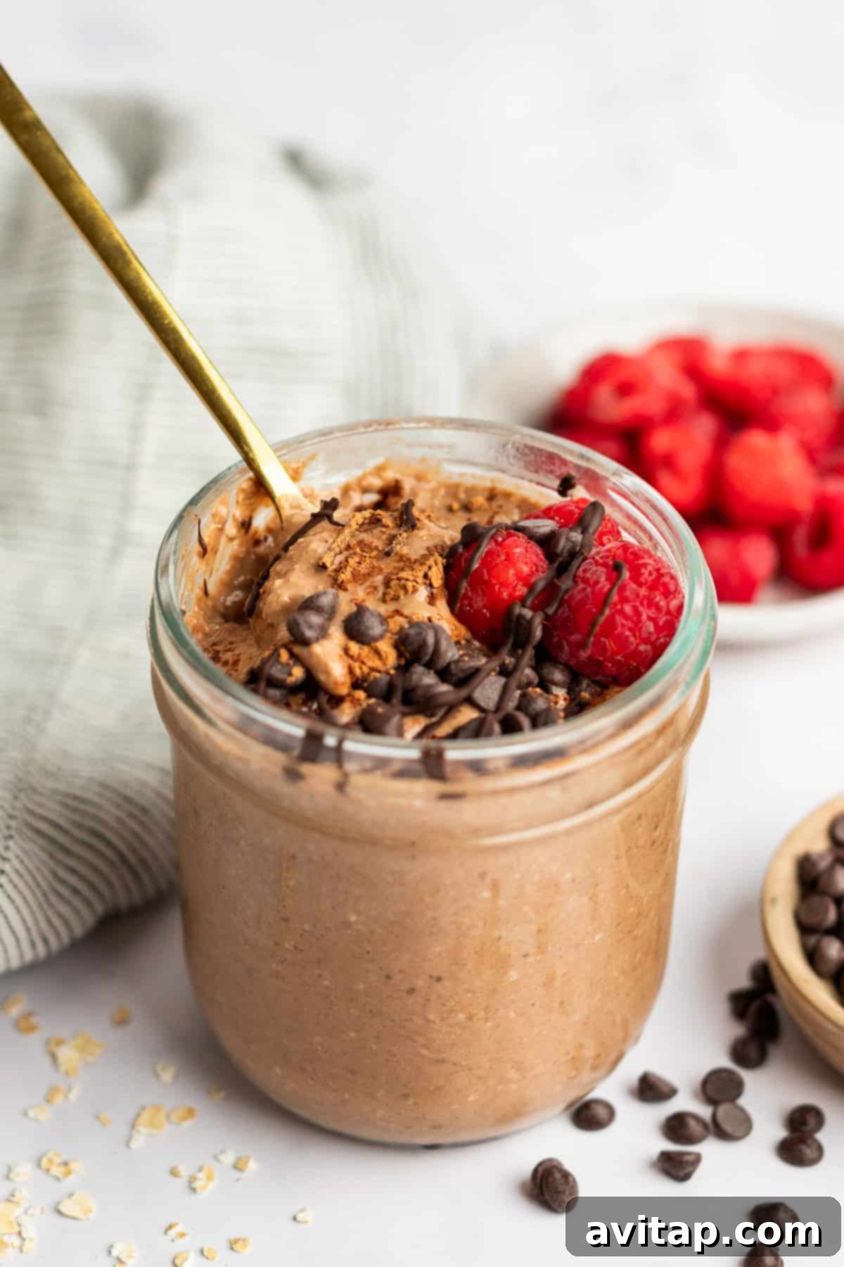 Velvet Chocolate Overnight Oats 2 A bowl of creamy chocolate overnight oats topped with fresh berries and a drizzle of chocolate sauce, ready for a healthy breakfast.