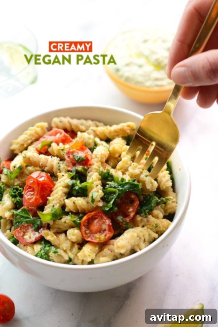 Creamy vegan pasta with sautéed kale and tomatoes.