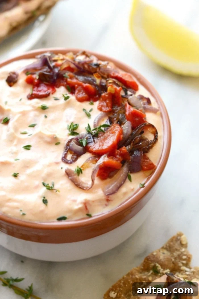 With Sunday football back in action, this Skinny Roasted Red Pepper and Goat Cheese Dip makes for the most perfect appetizer. It’s made with a non-fat Greek yogurt base, pureed roasted red peppers, and goat cheese! Healthy skinny roasted red pepper and goat cheese dip with Greek yogurt base