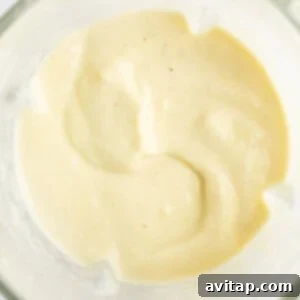 A close-up of a bowl containing smooth, creamy, beige-colored sauce or dressing, demonstrating the perfect blended consistency.