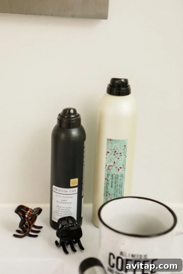 Close-up of a high-quality curling iron, essential hairspray, and dry shampoo used for creating loose waves.