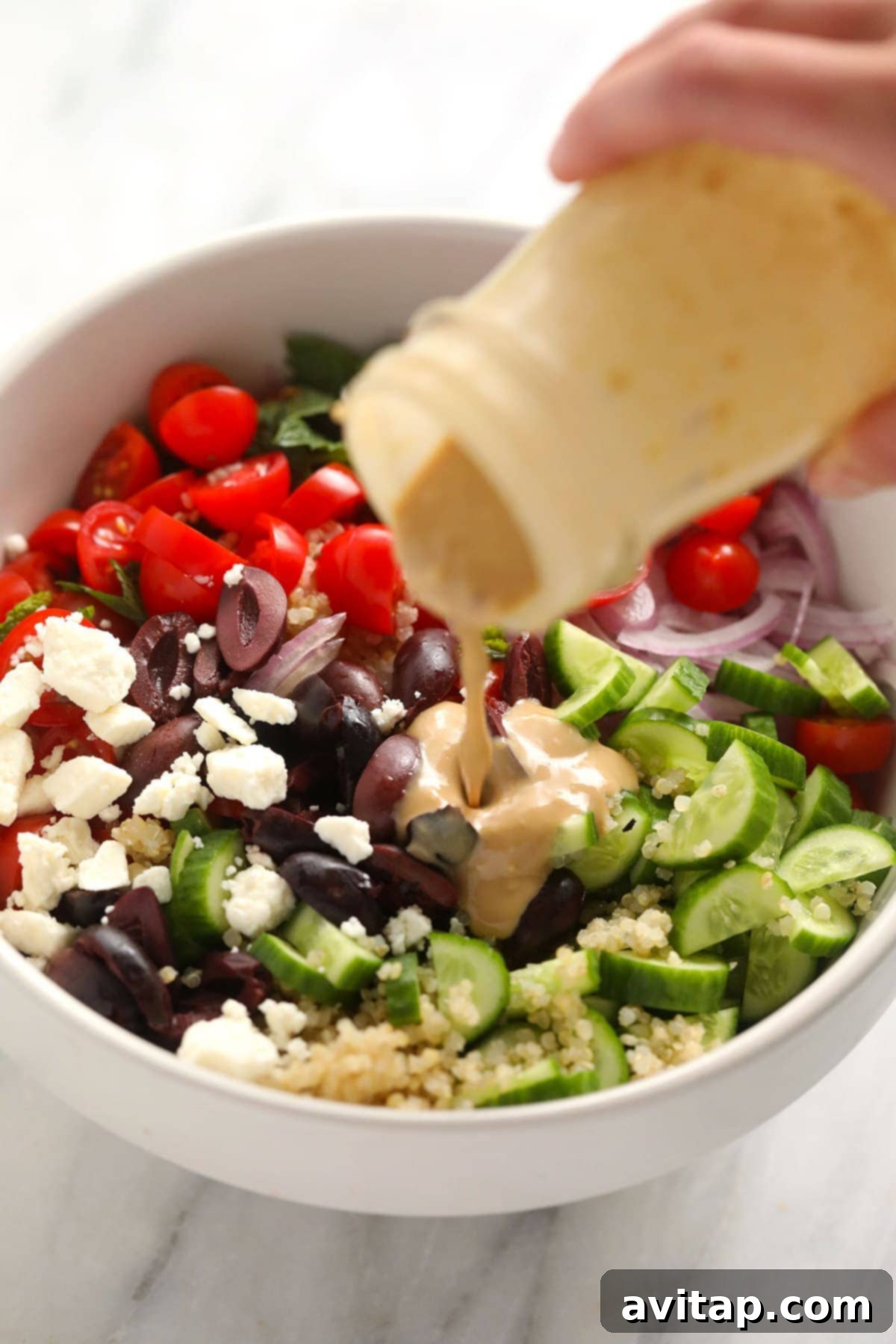 Fresh ingredients for Mediterranean Quinoa Salad laid out, including quinoa, vegetables, and feta cheese.