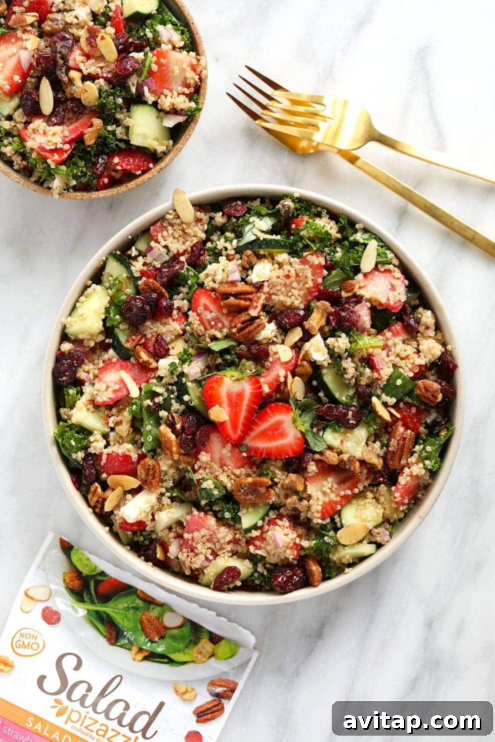 A vibrant Strawberry Quinoa Salad with massaged kale, fresh strawberries, cucumber, and feta cheese.