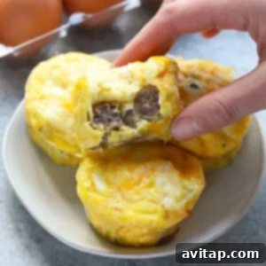 A person grabbing an egg muffin from a plate.
