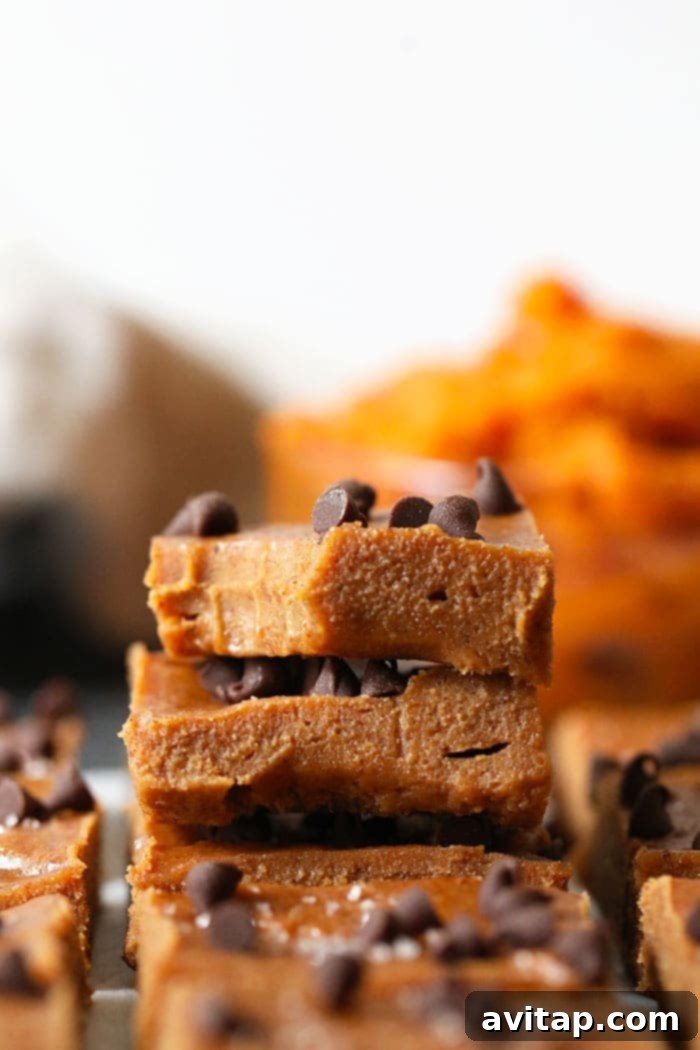 A stack of perfectly cut pumpkin almond butter freezer fudge squares, showcasing their inviting texture and rich color