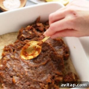 Gooey Pecan Pie Bars 3 A person effortlessly prepares easy pecan pie bars by pouring a spoonful of pecans into a baking dish with date caramel.