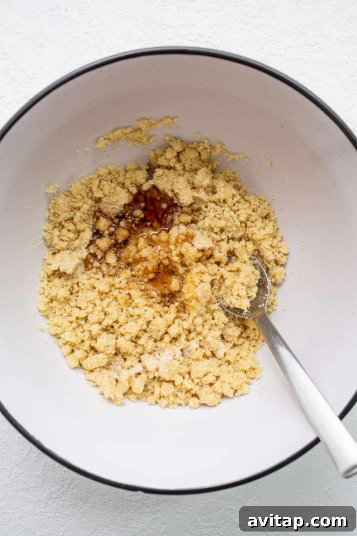 Essential ingredients for almond flour shortbread cookies, including almond flour, butter, and maple syrup, artfully arranged in a bowl.