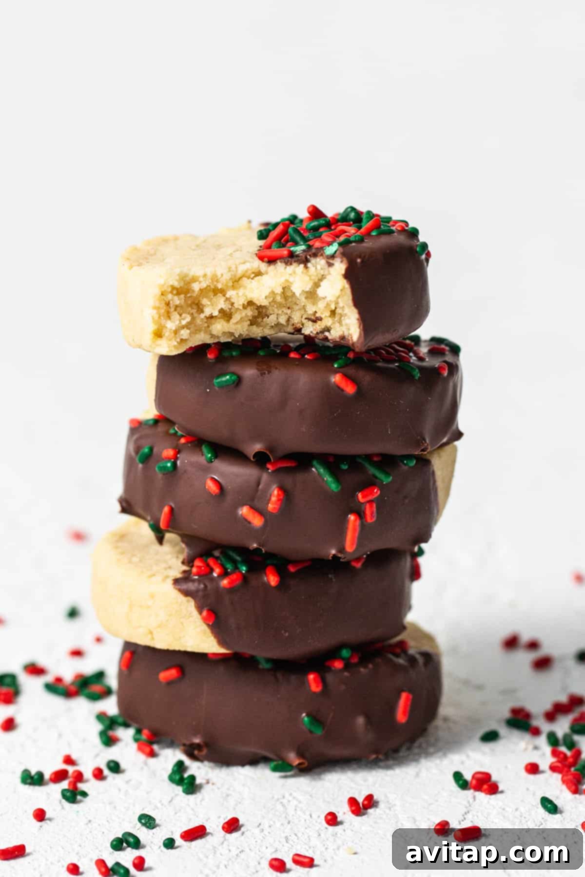 A stack of perfectly baked shortbread almond flour cookies, adorned with chocolate and sprinkles, showcasing their golden edges and inviting texture.