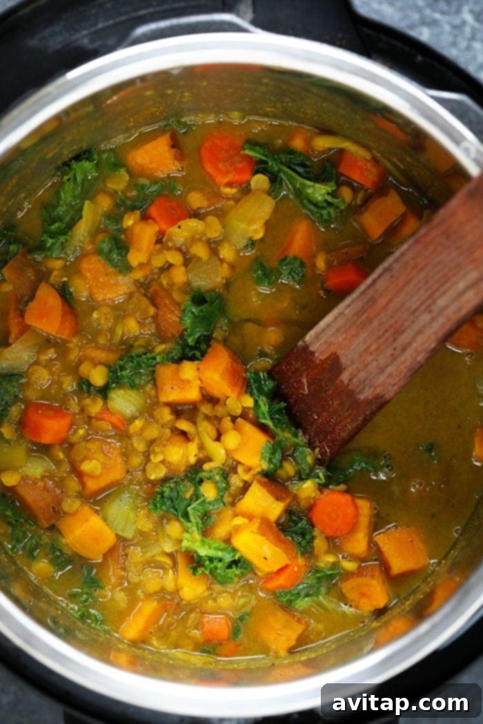 The Instant Pot working its magic on a delicious sweet potato curry. Instant Pot Sweet Potato Curry simmering inside an Instant Pot, showcasing the rich texture before the final ingredients are added.