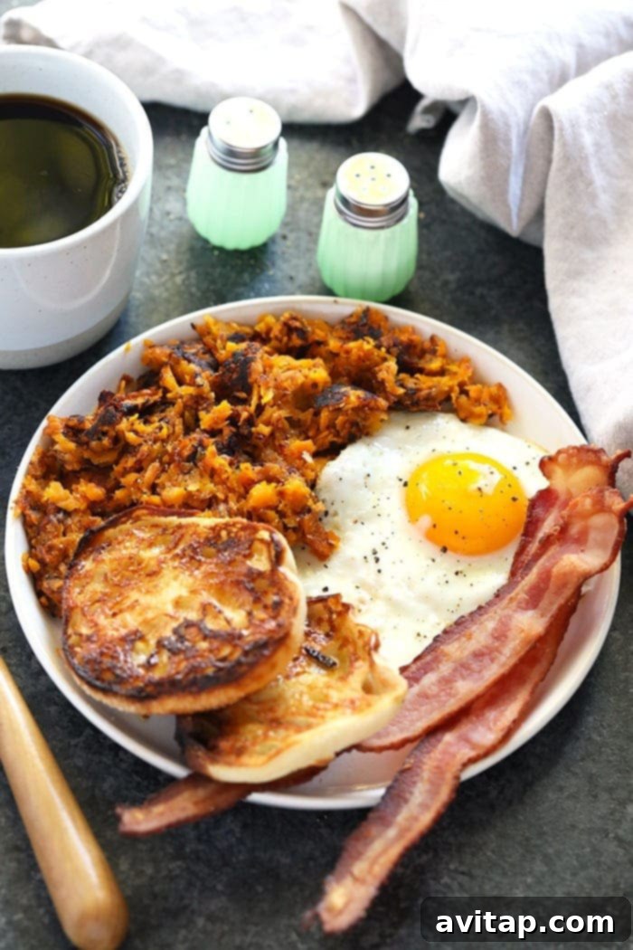 A breakfast plate featuring crispy sweet potato hash browns alongside eggs and avocado.