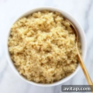 Close-up of fluffy cooked quinoa in a bowl, highlighting its texture and readiness for use in various dishes.