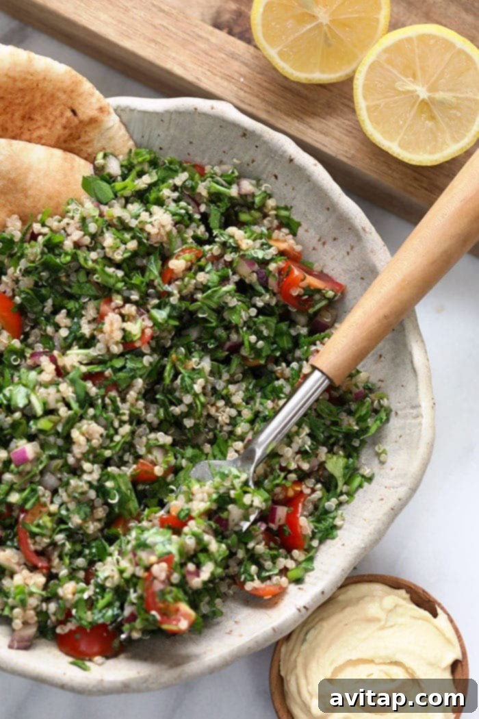 A person taking a bite of the fresh and flavorful quinoa tabouli, illustrating its deliciousness and ease of enjoyment.