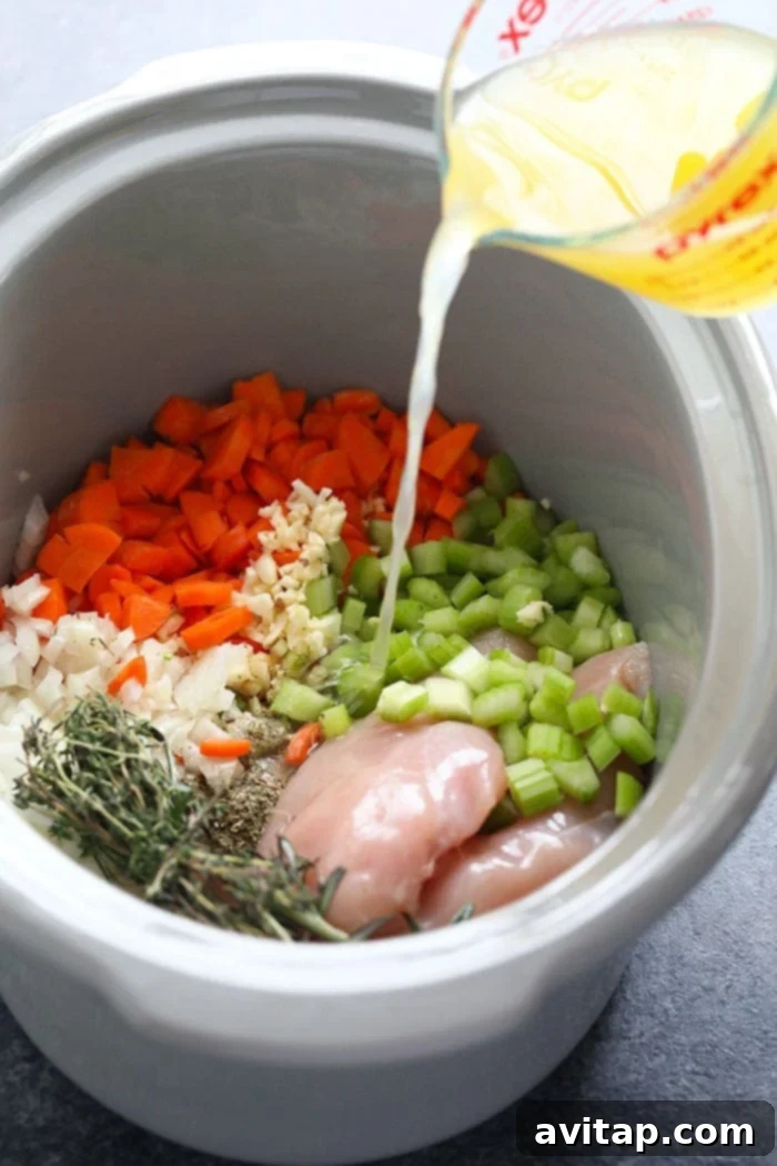 Cooked ingredients for chicken noodle soup in a crockpot, after slow cooking.