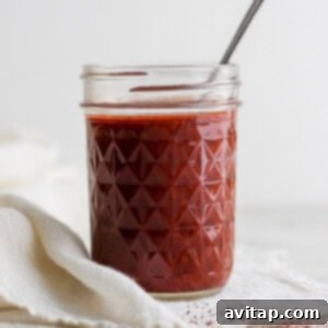 Jar of rich, red homemade enchilada sauce, ready for cooking.