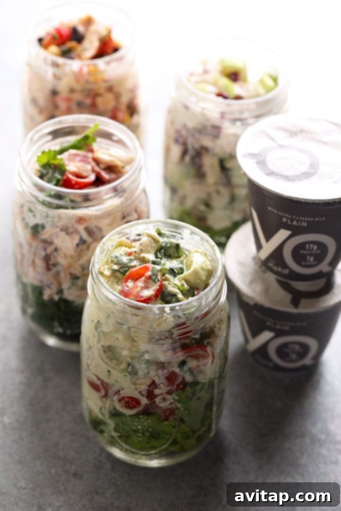 Four Healthy Chicken Salad Recipes 4 Variety of healthy chicken salads served in individual glass jars, ideal for convenient meal prep throughout the week
