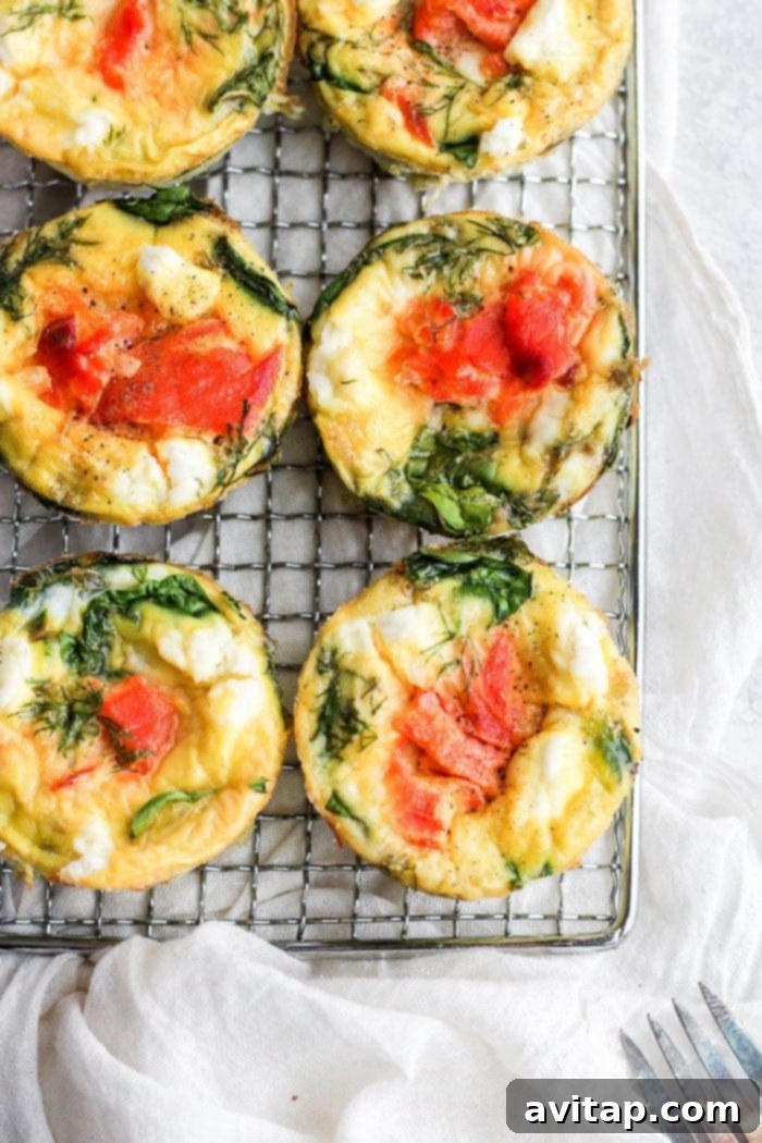 Freshly baked smoked salmon breakfast frittatas in a muffin tin, straight from the oven.