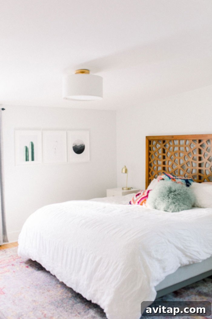 King-size bed with a geometric headboard and crisp white bedding, adorned with colorful accent pillows.