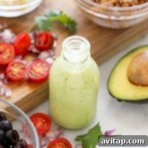 A jar of avocado cilantro lime dressing, showcasing its creamy texture and vibrant green color.