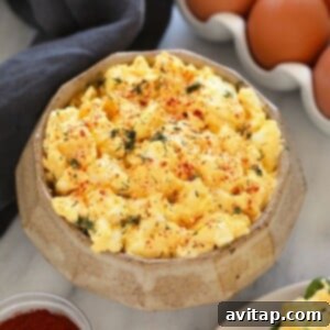 Healthy egg salad in a bowl, garnished with fresh dill. This image depicts a serving of the high-protein, low-carb recipe.
