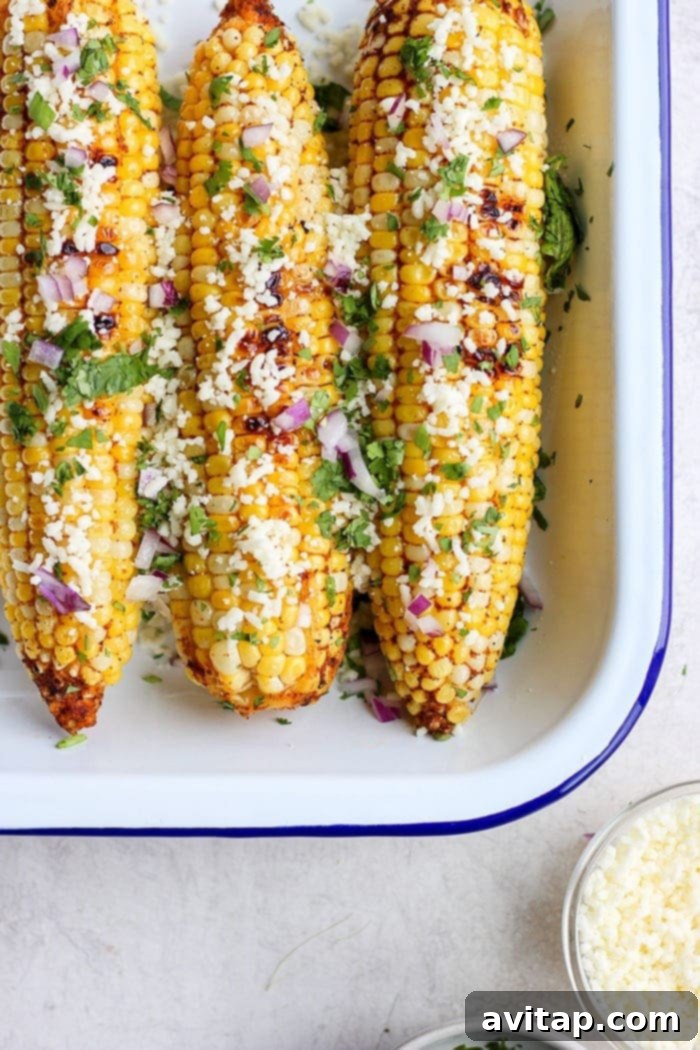 Delicious grilled Mexican street corn served in a tin container, ready to eat.