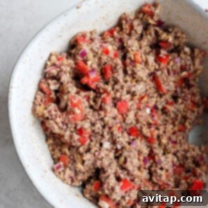 Savory Black Bean Burgers 5 A white bowl with a black bean burger and peppers.